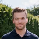 Thomas, founder of Returnolio, standing in front of a green hedge